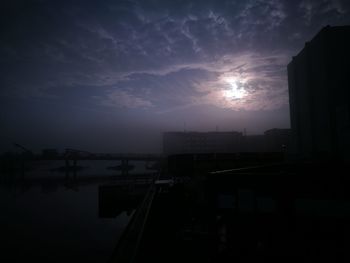 Silhouette buildings against sky at sunset