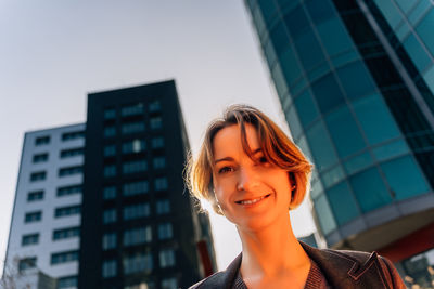 Smiling young woman in urban cityscape
