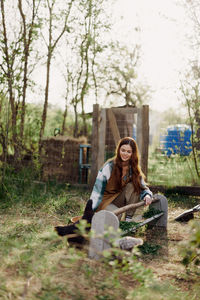 Smiling woman feeding hen in farm