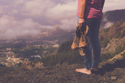 Low section of man standing on mountain