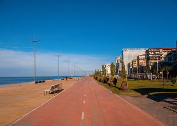 Panoramic view of city street against clear blue sky