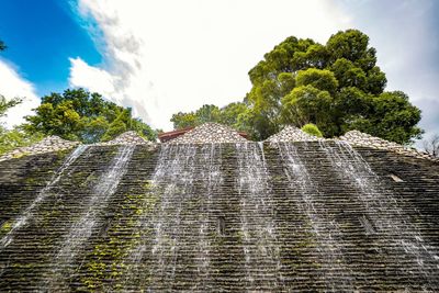 Low angle view of waterfall against sky