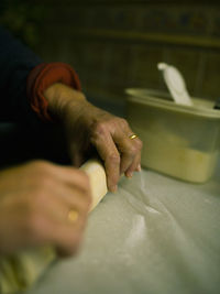 Close-up of cropped woman preparing food at home