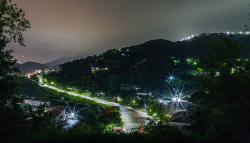 High angle view of illuminated city against sky at night