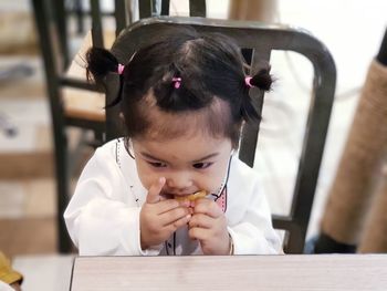 High angle view of cute girl eating at restaurant