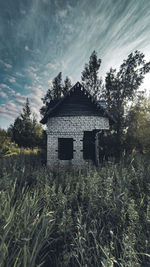 Abandoned house on field against sky