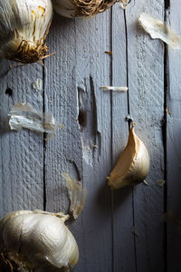 Close-up of garlic hanging on table against wall