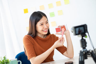 Portrait of smiling young woman using mobile phone