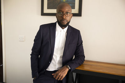 Portrait of man standing against wall