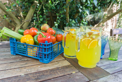 Close-up of drink in glass by vegetables on table