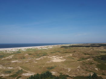 Scenic view of beach against blue sky