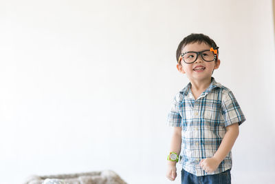 Portrait of boy standing against wall