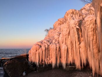 Panoramic view of rock formation in sea against clear sky