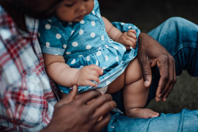 Midsection of couple holding baby