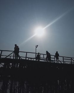 Low angle view of sun shining through clouds