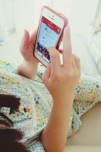 Cropped image of woman holding smart phone