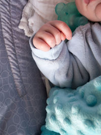 Low section of baby girl lying on bed