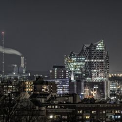 Illuminated cityscape against sky at night