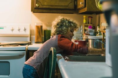 Close-up of boy washing hands in kitchen sink