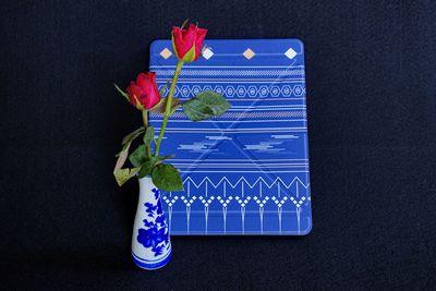 Close-up of blue flowers on table against black background