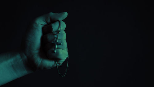 Close-up of person hand against black background