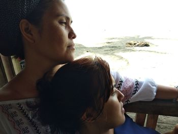 Rear view of mother and daughter at beach