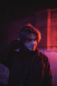 Portrait of young man standing against wall