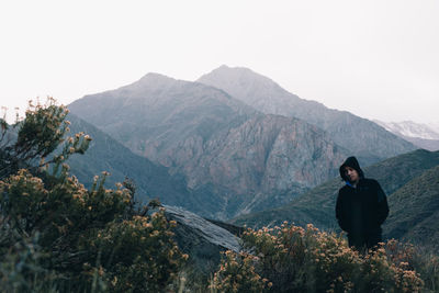 Man looking at mountains against sky