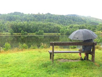 Scenic view of field by lake