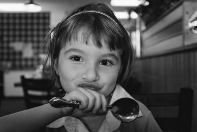 Close-up portrait of girl holding spoon 