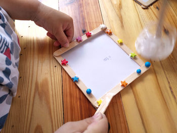 Cropped image of person holding paper on table