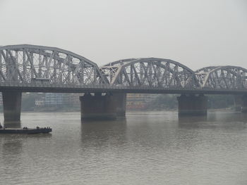 Vivekananda setu over hooghly river against sky