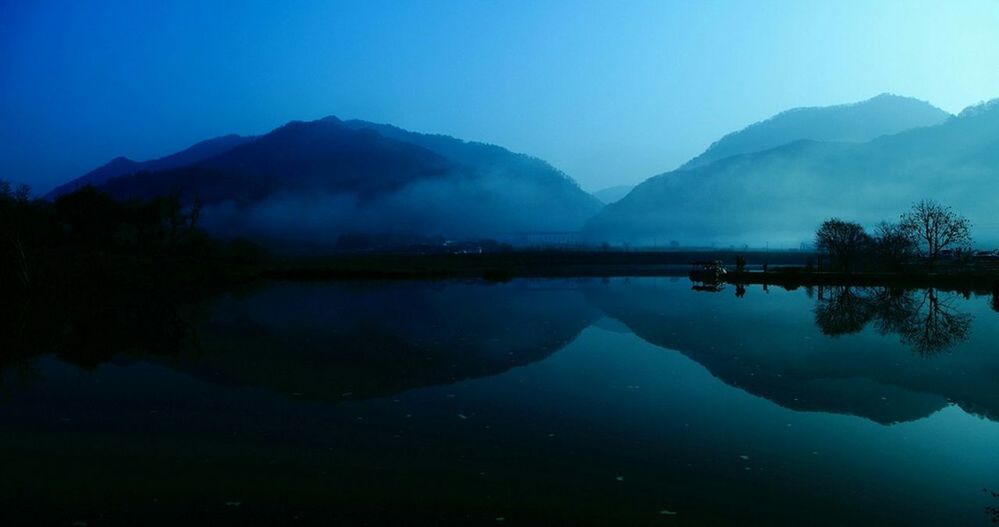 water, mountain, tranquil scene, tranquility, scenics, reflection, lake, beauty in nature, mountain range, blue, clear sky, nature, standing water, waterfront, idyllic, copy space, calm, sky, majestic, dusk