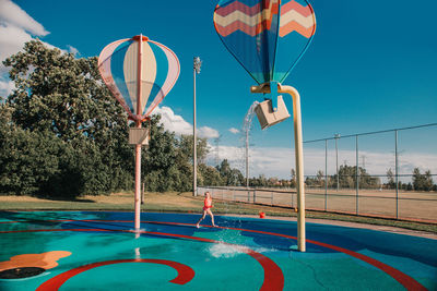 Girl playing on splash pad playground on summer day. seasonal water sport activity for kids outdoor.