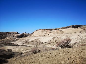 Scenic view of desert against clear blue sky