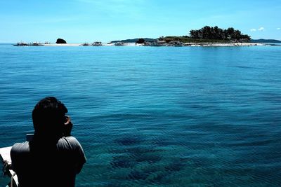 Rear view of man on beach against clear sky