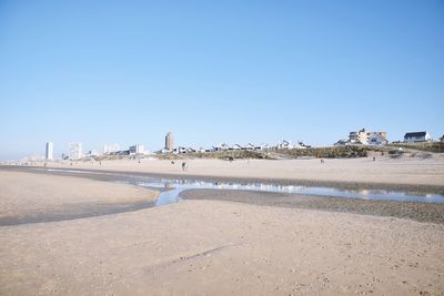 Scenic view of beach against clear blue sky