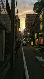 Man walking on road along buildings