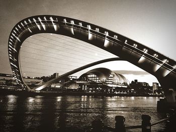 Bridge over river in city against clear sky