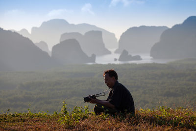 Man on field by mountains against sky