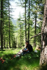 Man sitting with dog in forest
