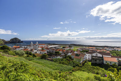 Scenic view of sea by buildings against sky