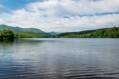 Scenic view of lake by mountain against sky