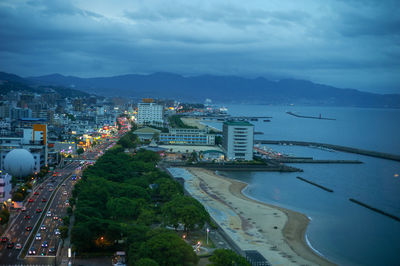 High angle view of city by sea against sky