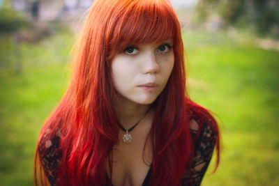 Portrait of sensuous woman with redhead standing at yard