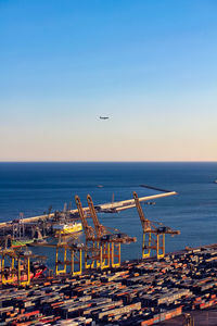 Airplane flying over sea against clear sky