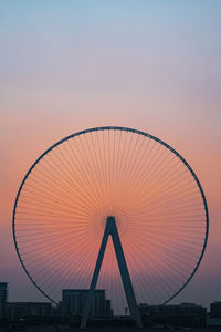 Ferris wheel in city against clear sky