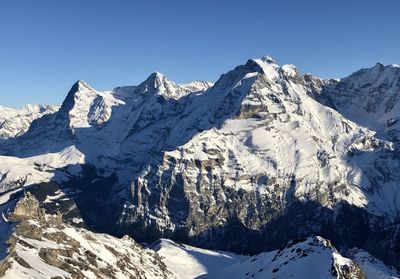 Scenic view of snowcapped mountains against clear sky