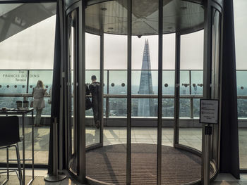 Reflection of people on glass window at airport