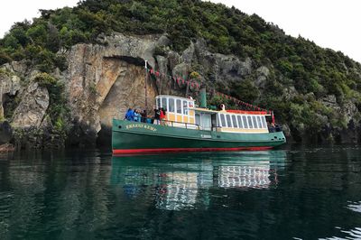 View of boats in water against mountain